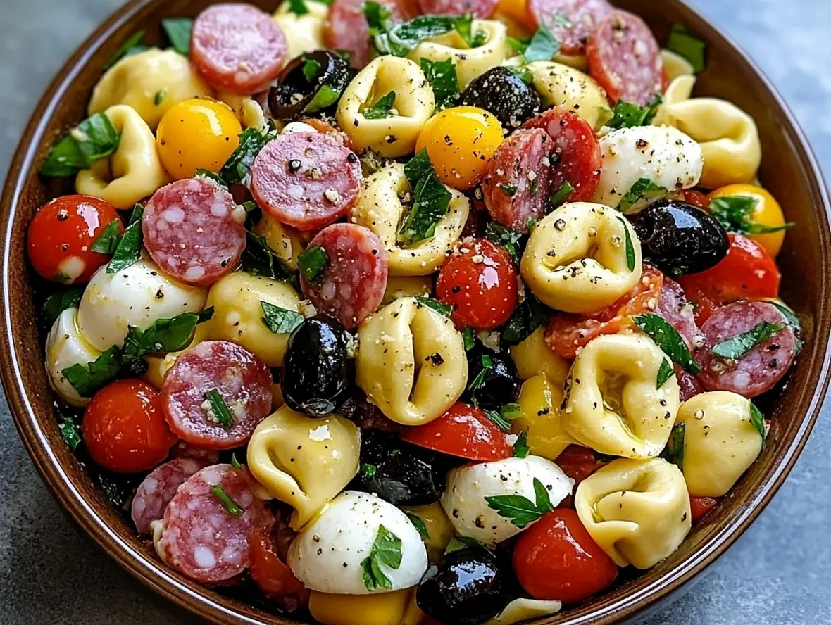 Delicious pasta salad with tortellini, colorful vegetables, and chicken in a bowl.