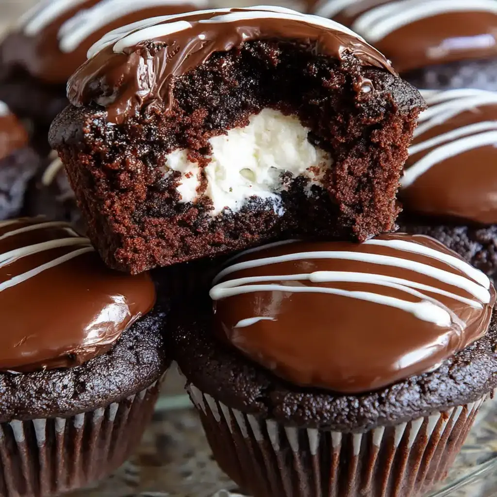 Homemade Hostess Chocolate Cupcakes with white icing swirl and chocolate ganache topping.
