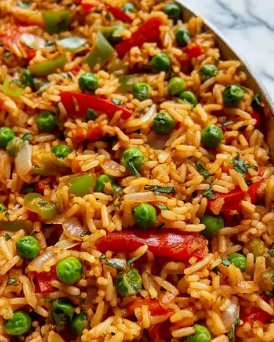 A vibrant pot of Vegetable Jambalaya with bell peppers, zucchini, and rice, steaming and ready to serve.